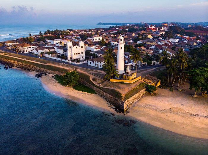 “Galle Fort lighthouse overlooking the ocean at sunset”