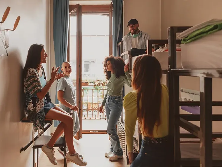 group of happy tourists talking in a hostel