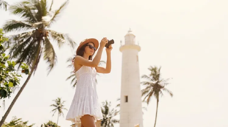 girl wearing a white frock near a light house in sri lanka