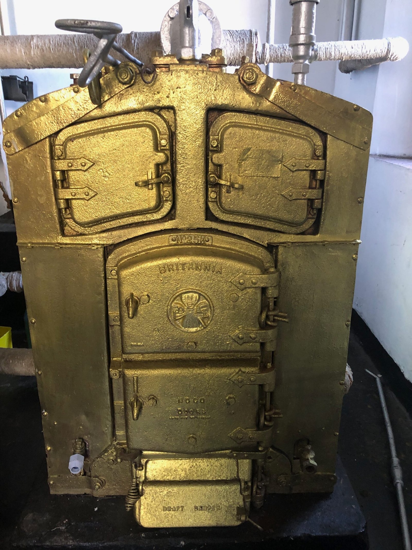 Haputhale Travel Guide 46 A close-up of the Britannia furnace door in Adisham's boiler room, its brass casing catching the light.