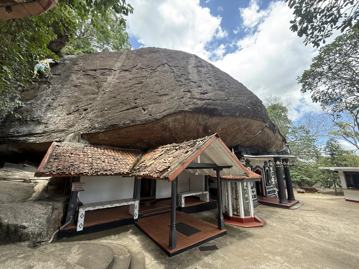 Tiled roof beneath a large boulder at Sankapala temple.