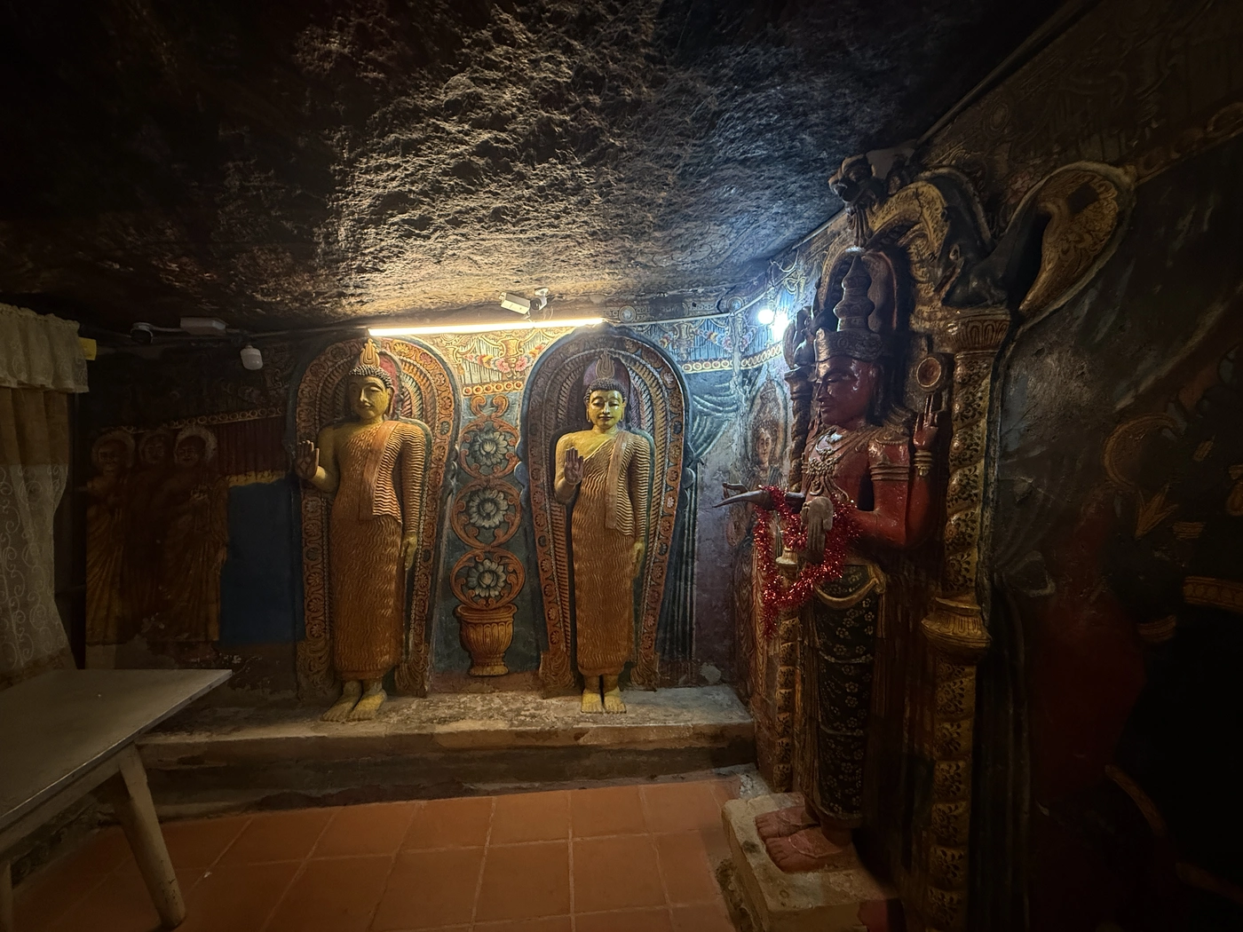 Standing Buddha statues and deity in the cave shrine