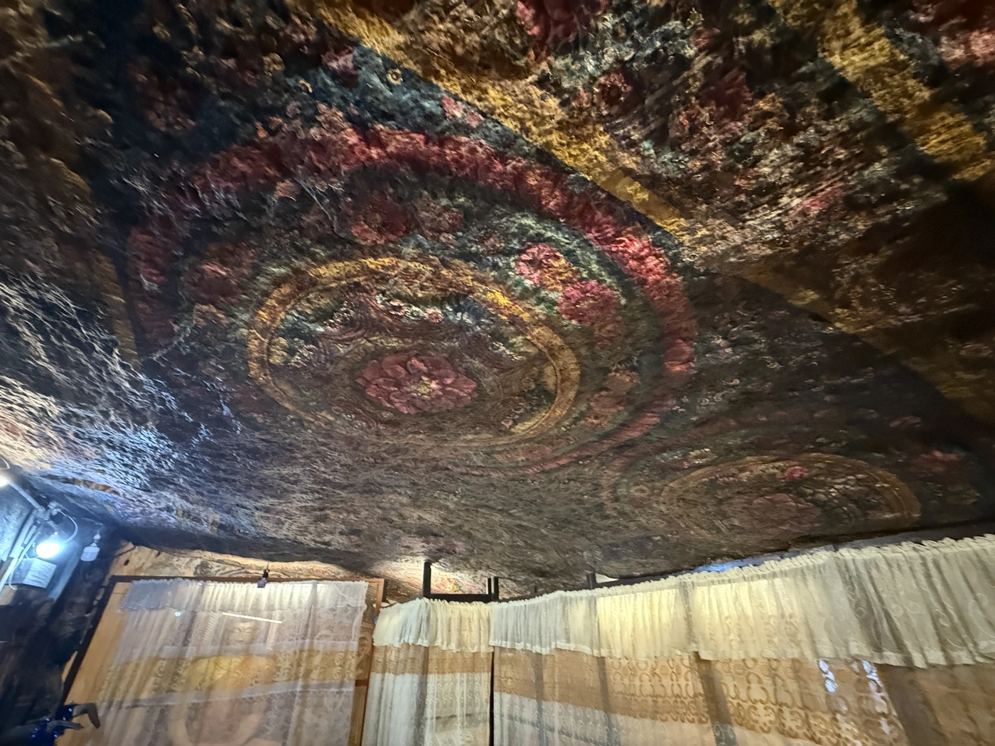 Very old painted designs cover the rock ceiling of the cave shrine.