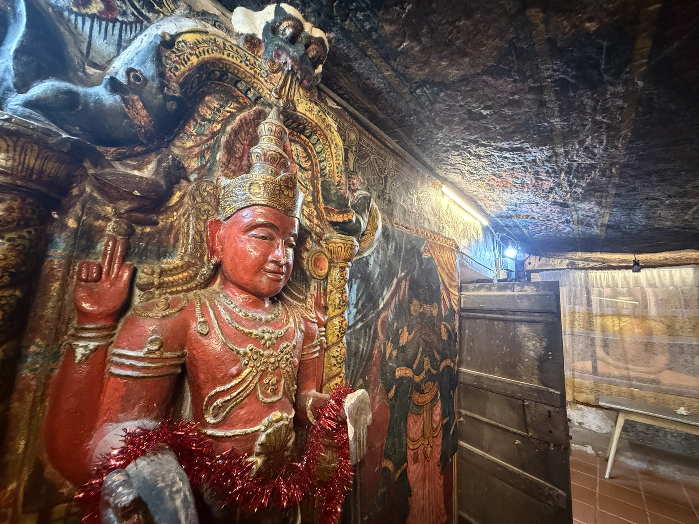 Red deity statue inside the cave shrine