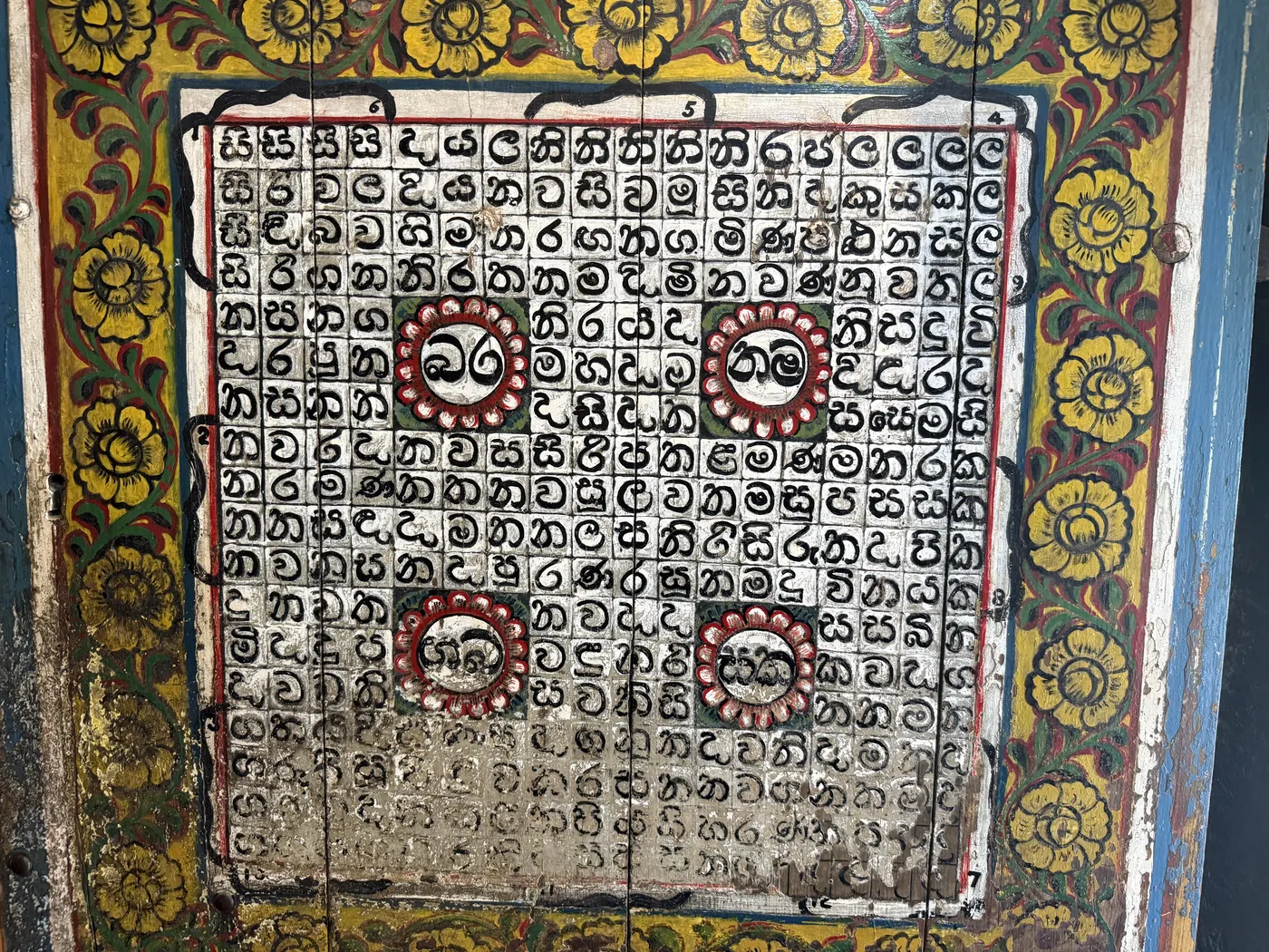 Painted door panel with a Sinhala letter grid