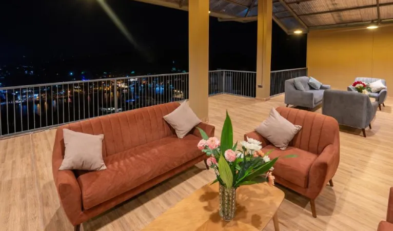 Rooftop lounge with orange sofas at night at 360 View Point Kandy