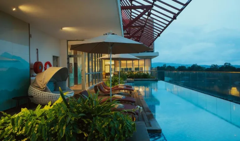 Rooftop pool deck with loungers and umbrellas at Kandy Myst by Cinnamon