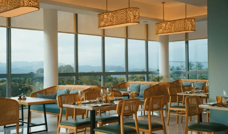 Restaurant with rattan chairs and pendant lamps at Kandy Myst by Cinnamon