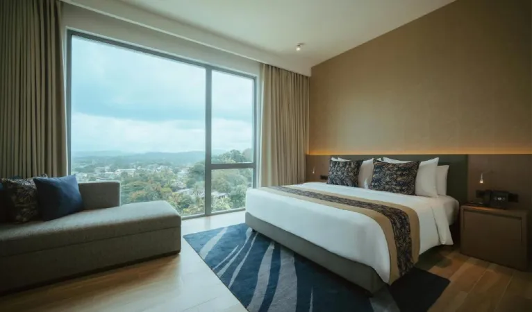 Guest room with floor-to-ceiling window and hill views at Kandy Myst by Cinnamon