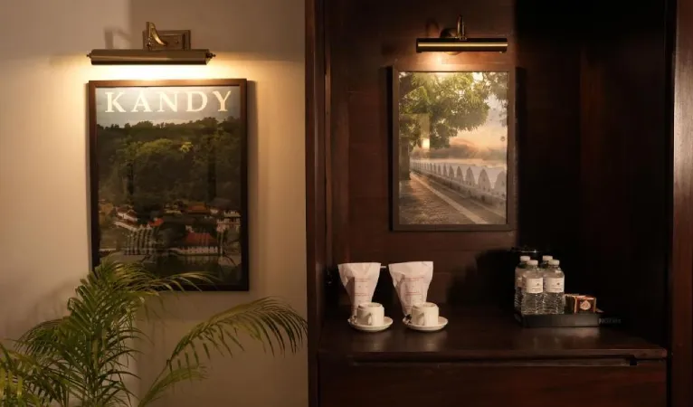 In-room tea station beneath a vintage Kandy poster at Hotel Casamara
