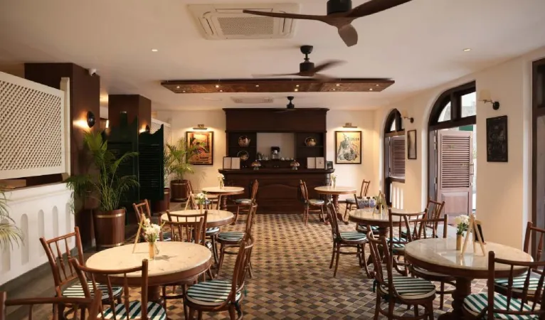 Cafe at Hotel Casamara with round tables, patterned tiles and ceiling fans