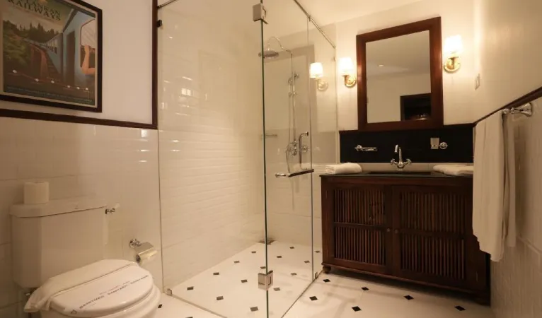 Bathroom with glass shower and dark wood vanity at Hotel Casamara