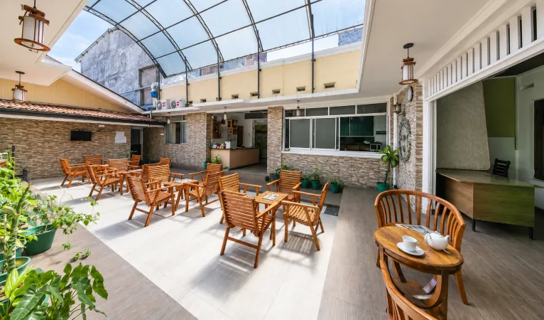 Glass-roofed courtyard with wooden chairs at Charlton Kandy Rest