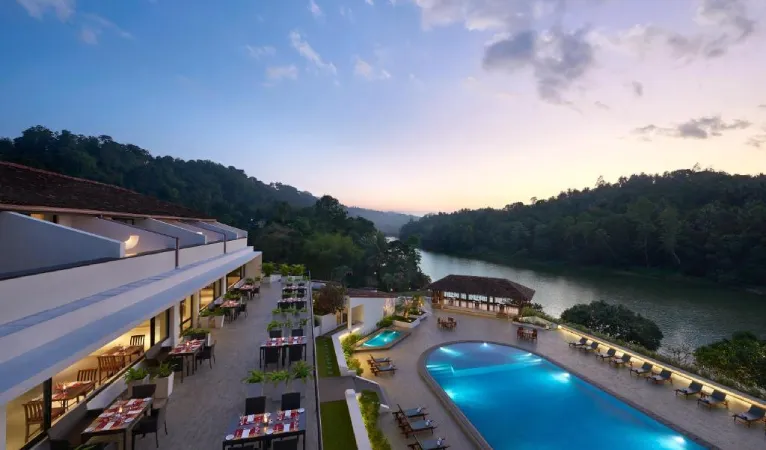 Pool and restaurant terrace beside the Mahaweli River at dusk, Cinnamon Citadel Kandy