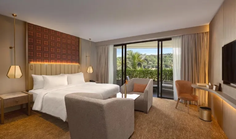 Guest room with king bed, armchairs and balcony doors at The Golden Crown Hotel Kandy