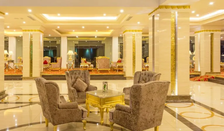 Gold-pillared lobby lounge with ornate armchairs at The Grand Kandyan Hotel