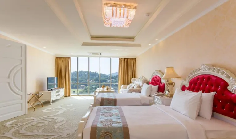 Twin room with red tufted headboards and a chandelier at The Grand Kandyan Hotel