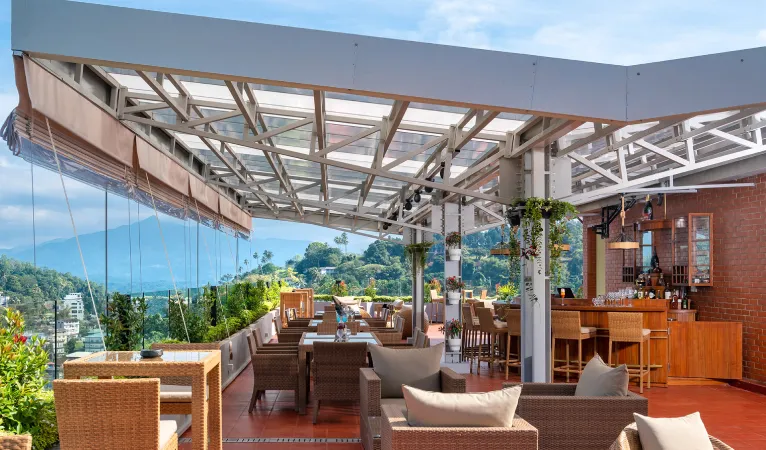 Rooftop restaurant under a glass canopy with mountain views at Grand Serendib Hotel