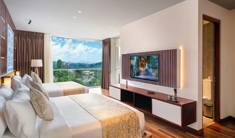 Guest room with a large window facing green hills at Grand Serendib Hotel Kandy