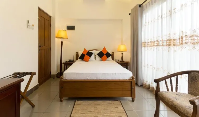 Double room with orange cushions and bedside lamps at Heaven Seven Hotel Kandy