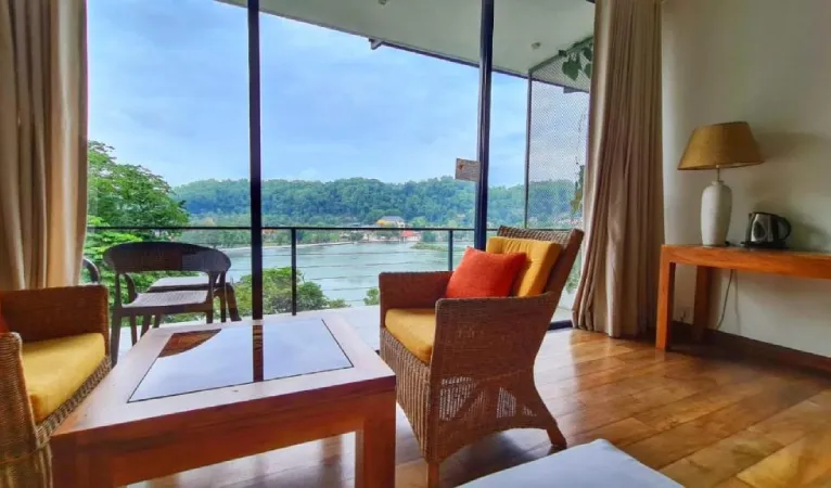 Room seating by a window overlooking Kandy Lake at Lakewood Residence