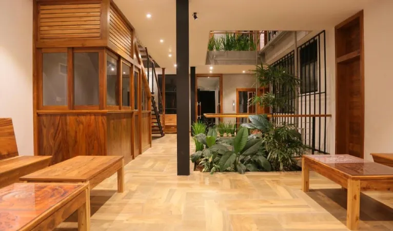 Lobby with wooden furniture and an indoor plant courtyard at Lakewood Residence