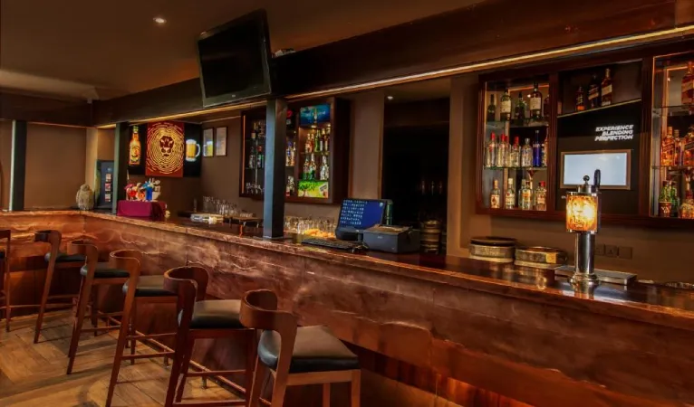 The Last Drop bar counter with stools at Kandy City Hotel by Earl's