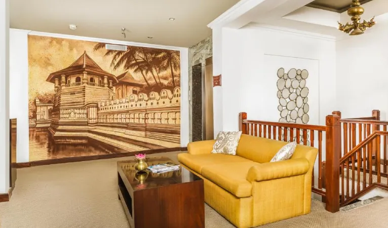 Lounge with yellow sofa and a Temple of the Tooth mural at Kandy City Hotel by Earl's