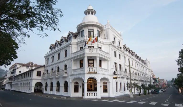 White colonial facade of Queens Hotel with its domed corner tower on Dalada Veediya, Kandy