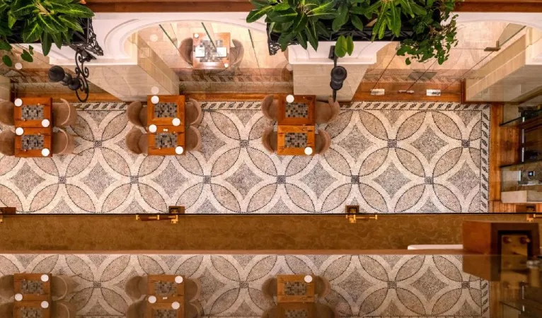 Overhead view of the restaurant's patterned tile floor and tables at The Radh Hotel