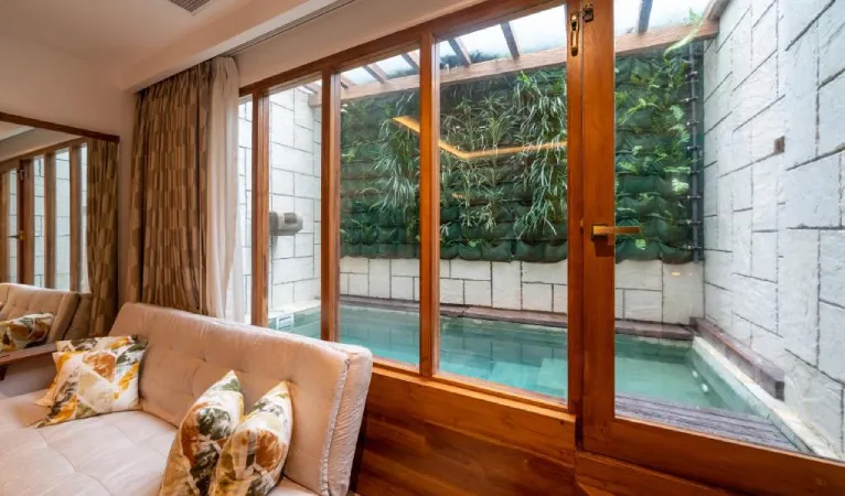 Suite sofa beside a private plunge pool and green wall at The Radh Hotel Kandy