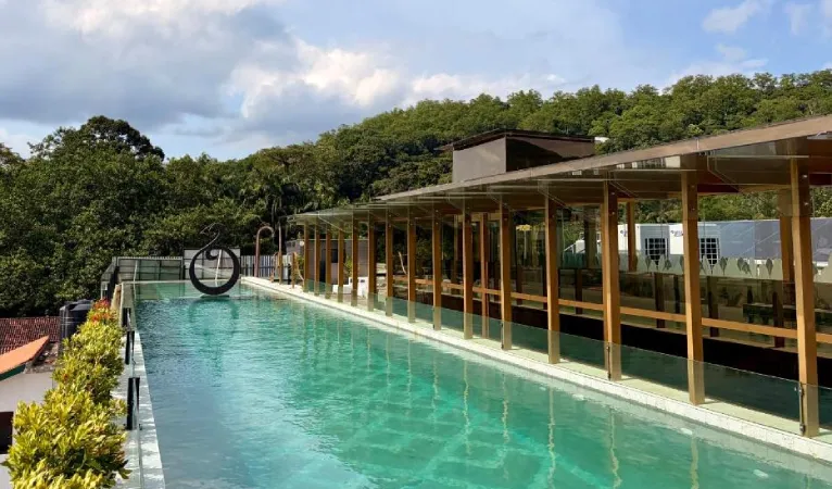Long rooftop pool with a wooden pergola at The Radh Hotel Kandy