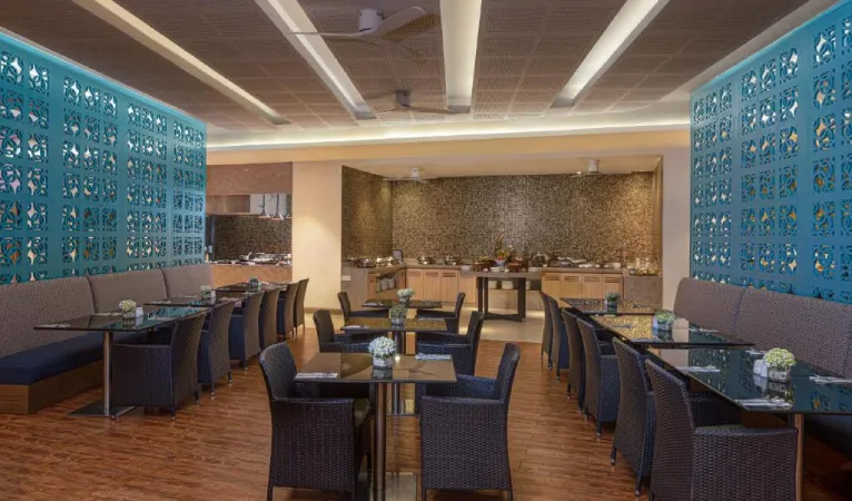 Restaurant with turquoise lattice panels and a buffet counter at Radisson Hotel Kandy