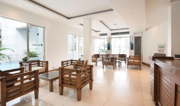 Lobby lounge with wooden armchairs at Senani Hotel Kandy