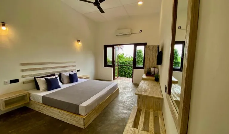 Guest room with platform bed and balcony door at Sesatha Lake Kandy