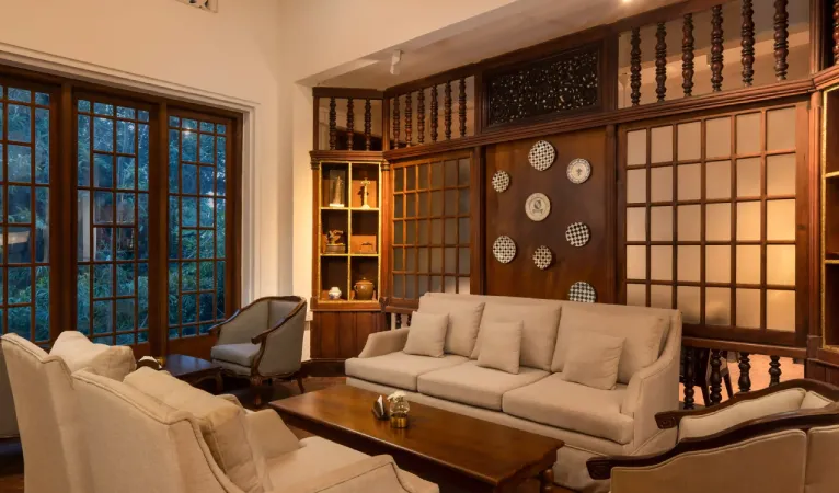 Lounge with cream sofas and carved wooden screens at Hotel Suisse Kandy