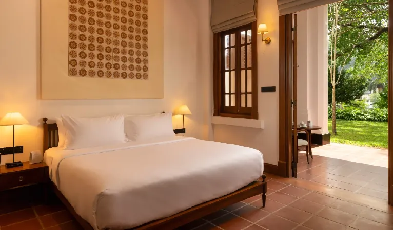 Hotel Suisse guest room with terracotta floor and doors opening onto the garden