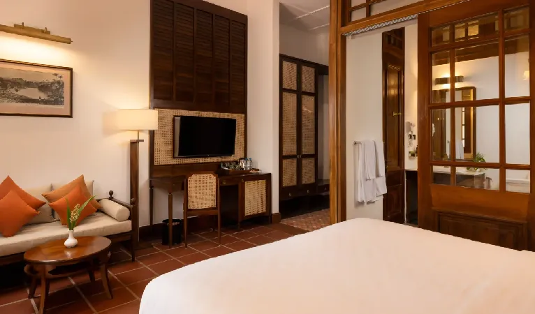 Seating corner with orange cushions in a heritage room at Hotel Suisse Kandy