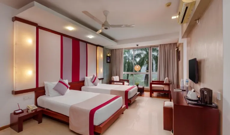 Twin room with red and white decor at Hotel Topaz Kandy