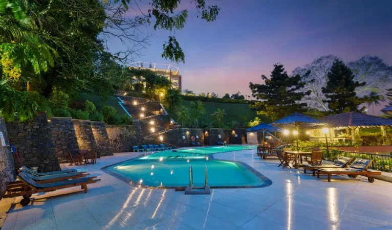 Lit swimming pool at dusk beside the hillside at Hotel Topaz, Anniewatta