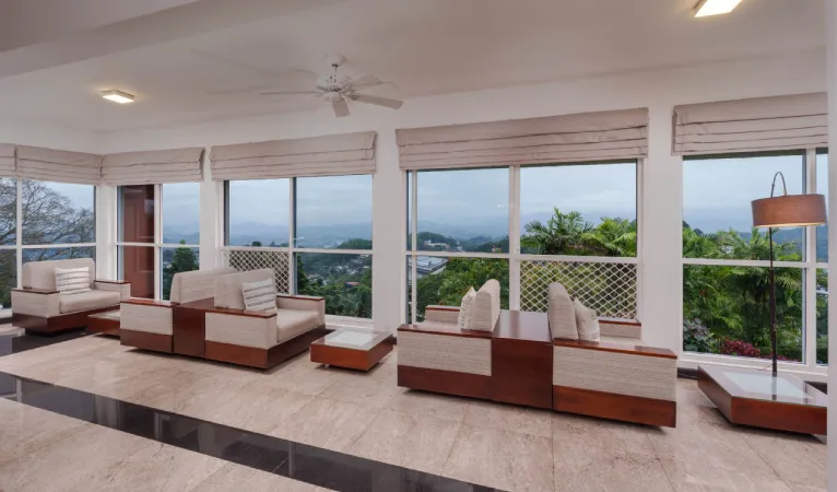 Lounge with floor-to-ceiling windows overlooking Kandy at Hotel Topaz