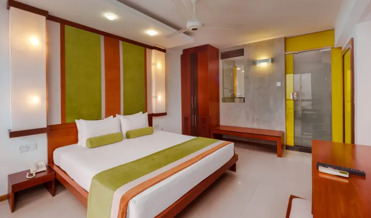 Double room with green and orange accents at Hotel Topaz Kandy
