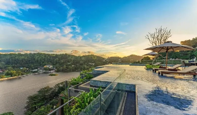 Infinity pool overlooking Kandy Lake at sunset at The Trees Kandy