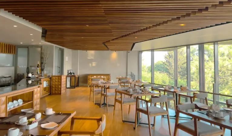 Restaurant with slatted wooden ceiling and window tables at The Trees Kandy