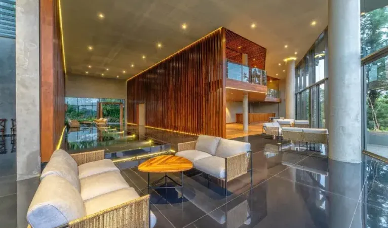 Lobby lounge with white sofas and a wooden screen at The Trees Kandy