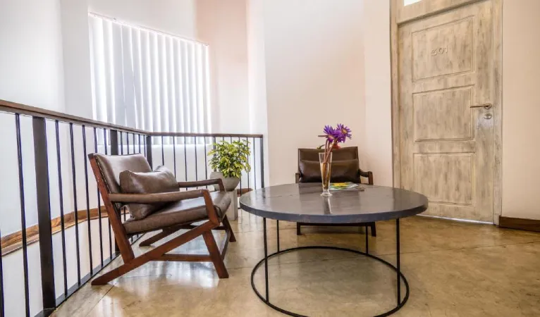 Seating area with armchairs beside the staircase at Viyana Boutique Hotel