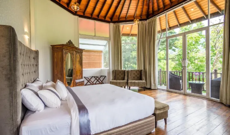 Bedroom with tufted headboard and glass doors to the balcony at Viyana Boutique Hotel